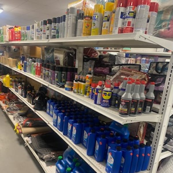 Shelves filled with various automotive products, including spray cans, oil, and other car care items.