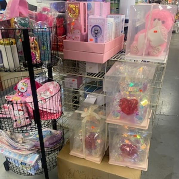 Variety of gifts and toys, including Hello Kitty items and teddy bears, displayed on shelves.