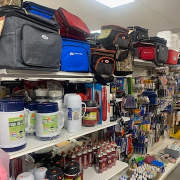 Shelves filled with various coolers, thermoses, and other general merchandise at Planada Cafe & Variety.